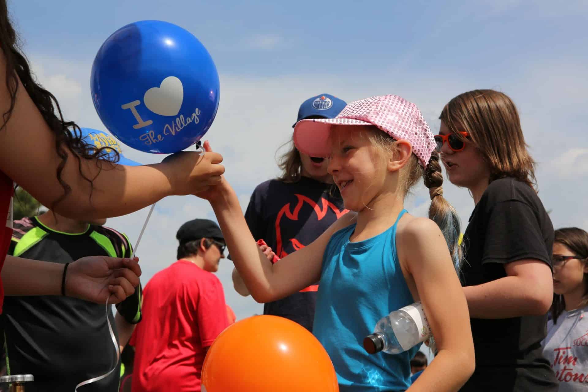 little girl getting a griesbach balloon Une petite fille qui reçoit un ballon « Griesbach ».
