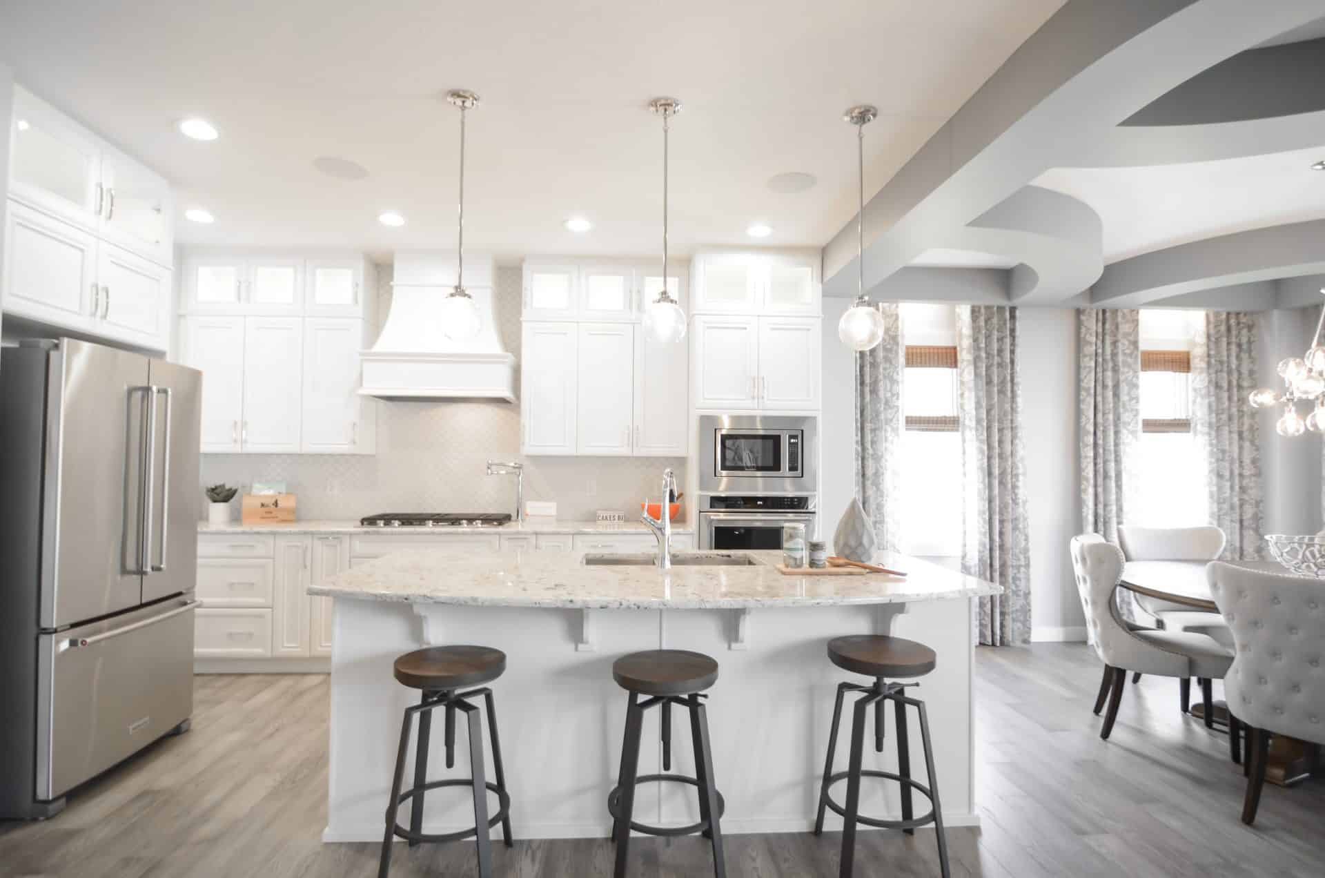 white kitchen with grey hardwood floors Cuisine blanche avec planchers de bois franc gris.