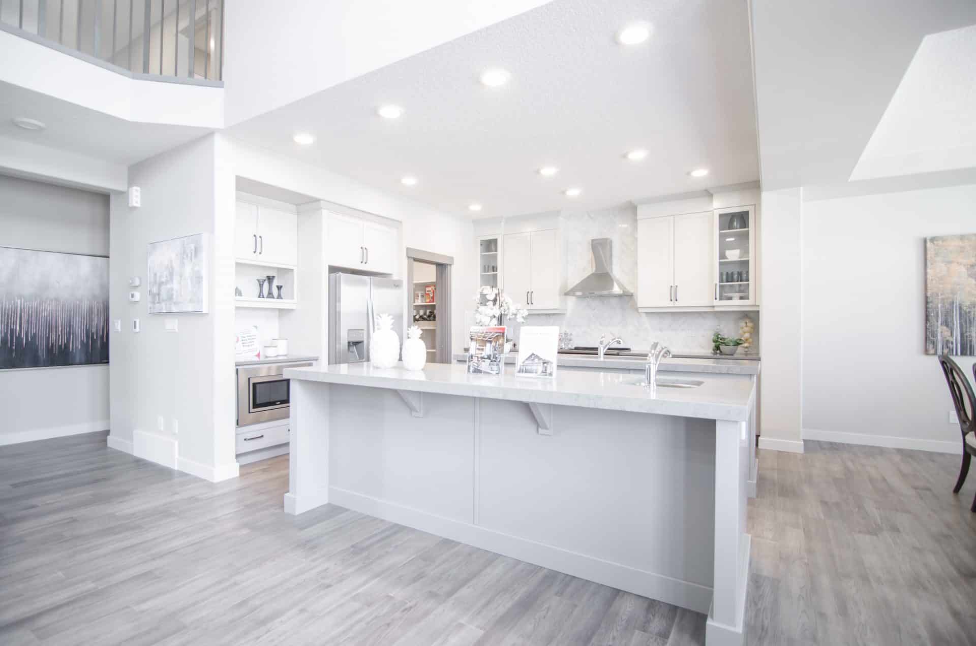 white kitchen and main area with marble countertops Cuisine blanche et espace principal avec comptoirs en marbre.