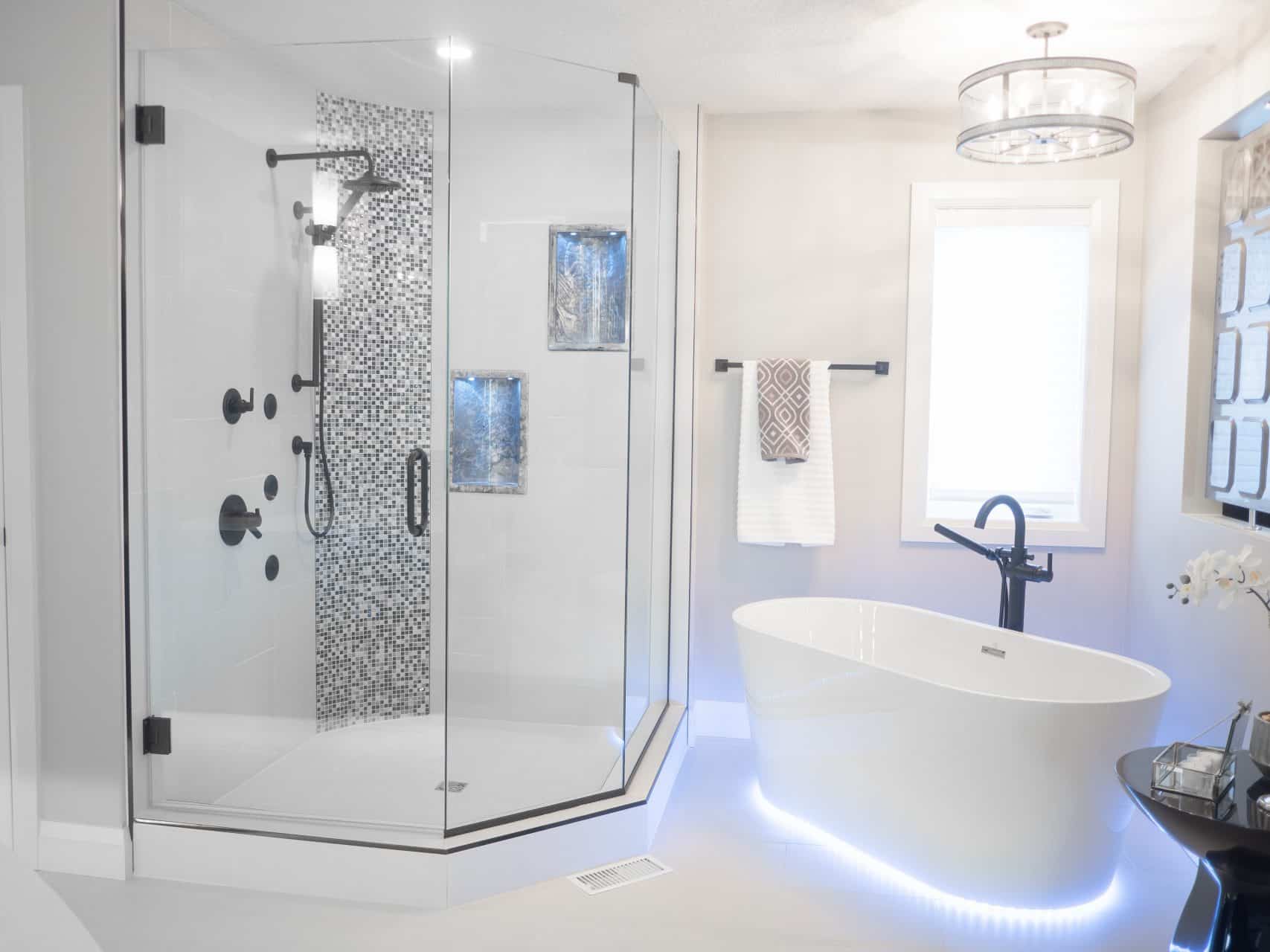 tall glass shower and deep bathtub with glow lights around it