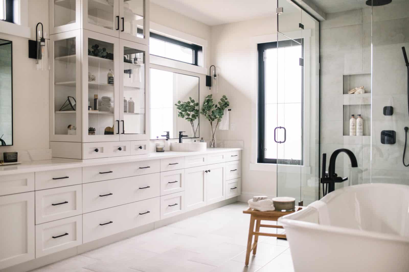 huge bathroom with white cabinets, counters, floor and large soaker tub Immense salle de bain avec armoires blanches, comptoirs, plancher et grande baignoire trempette.