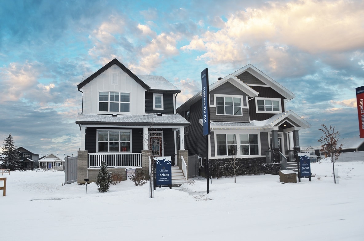 Two detached garage show homes. Signage indicates Homes by Avi’s Lochlan model and Impact Homes’ Carina model.