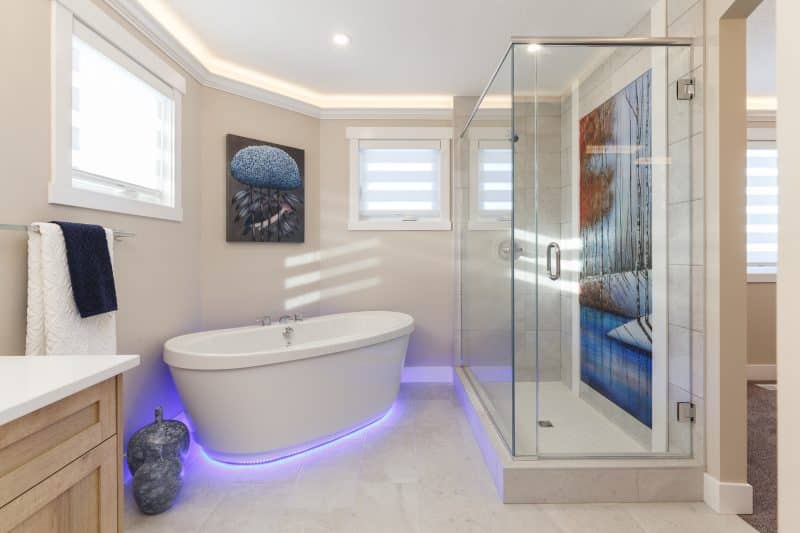 White tiled 5-piece bathroom with decorative shower.

Salle de bain blanche carrelée à cinq sanitaires comportant une douche décorative.