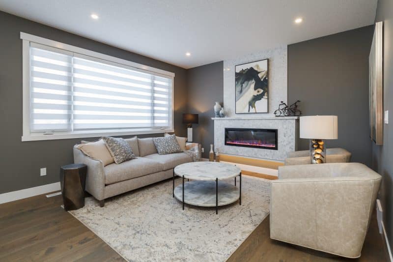 Living room with neutral decor and a tiled fireplace. 

Salon de style neutre doté d’un foyer carrelé.