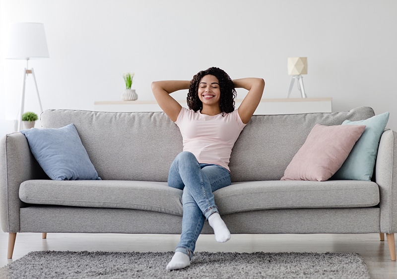 Woman relaxing on couch / Femme se relaxant sur le canapé