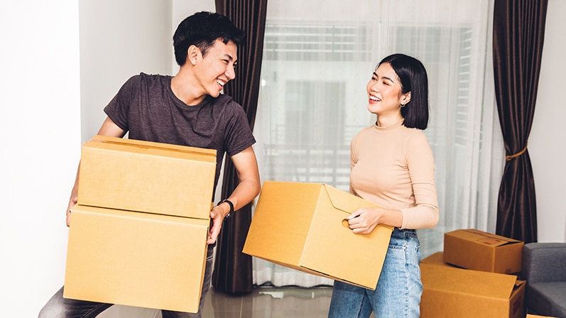 A young couple carrying boxes / Un jeune couple portant des cartons